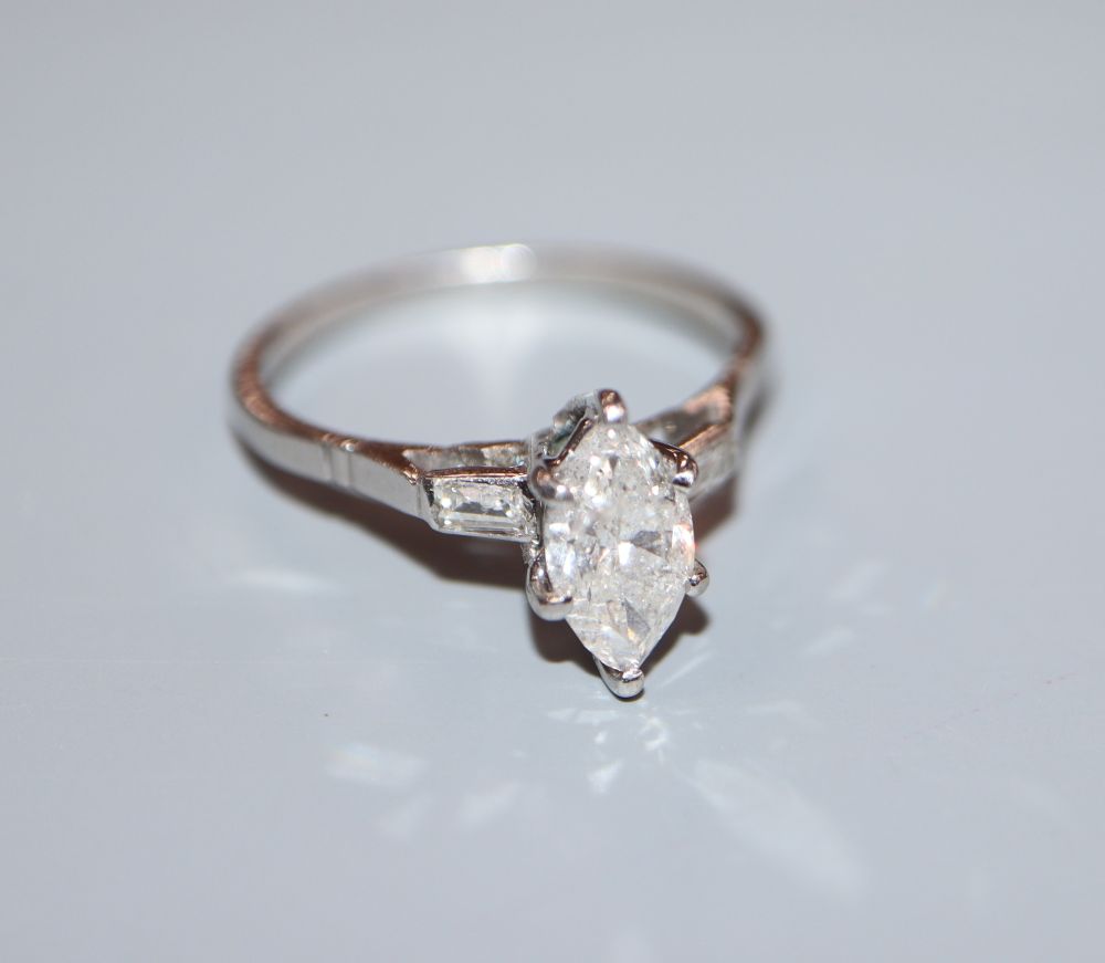 A white metal (stamped plat) and marquise diamond set dress ring with baguette cut diamond set shoulders, size P, gross 3.3 grams,